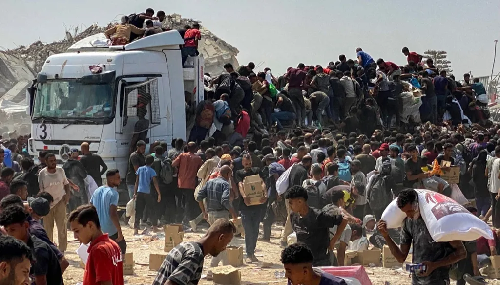 فلسطينيون في غزة يحتشدون عند شاحنة تحمل مساعدات (أ ف ب)