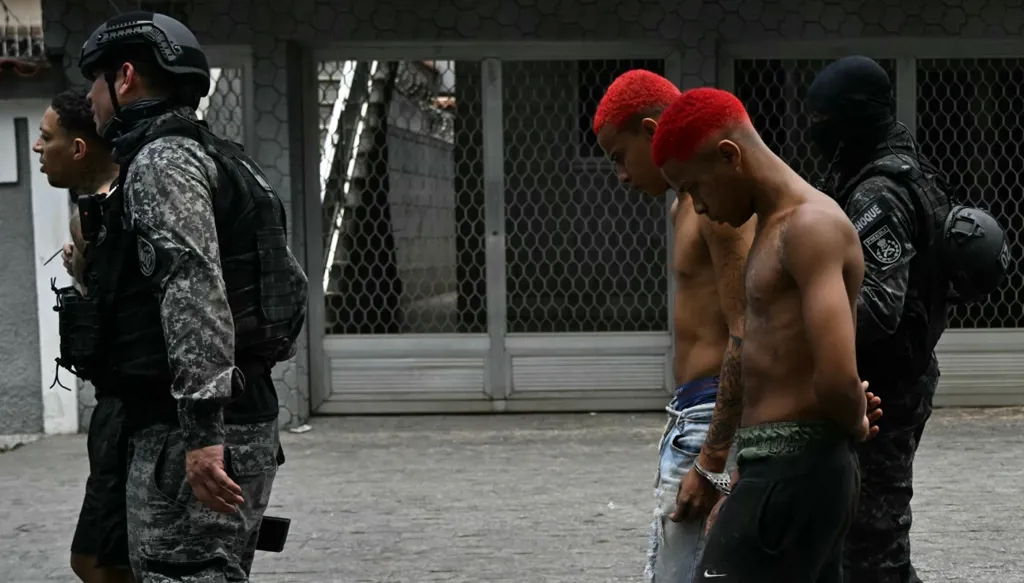 ضباط شرطة يرافقون مشتبه بهم تم القبض عليهم (أ ف ب)