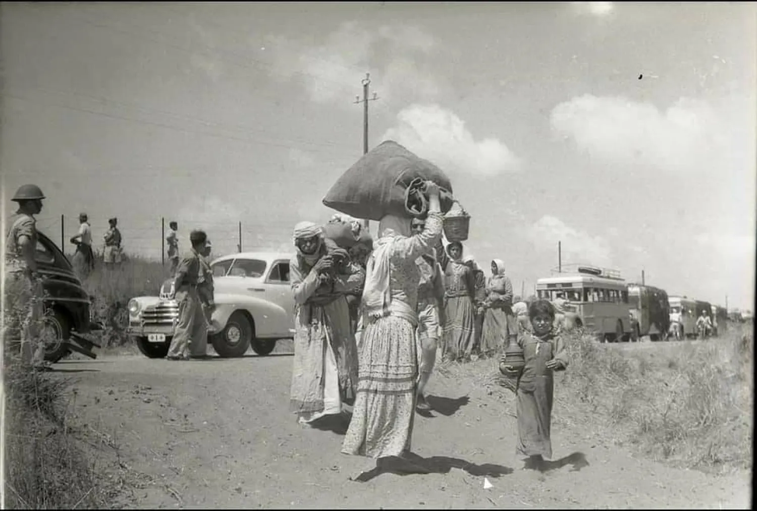 فلسطينيون معظمهم من النساء والأطفال في طريقهم للخروج من منازلهم بقرية الطنطورة في مايو 1948 (موقع فلسطين في الذاكرة)
