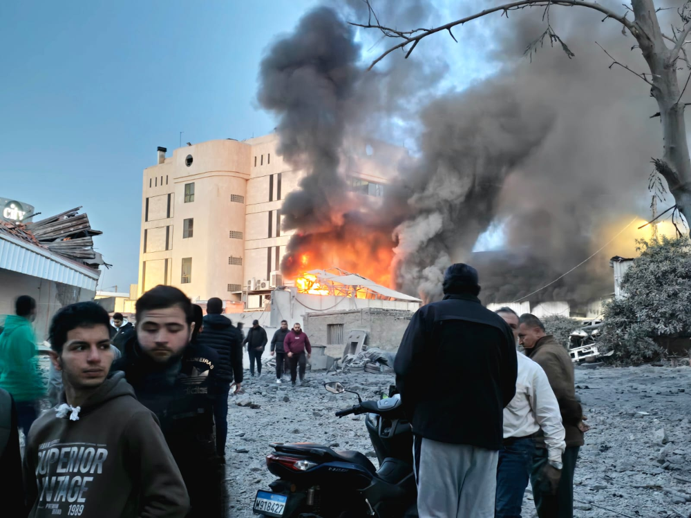 مواطنون يتجمعون حول الموقع الذي استهدفته الطائرات الإسرائيلية في صيدا أمس. (أحمد منتش)