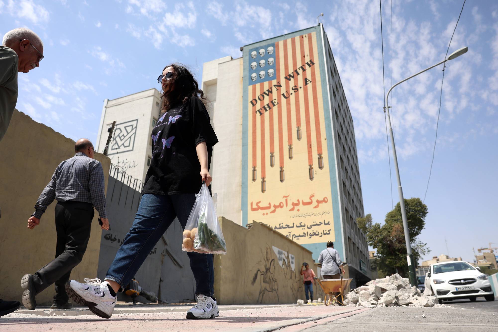 إيرانيون يمرُّون أمام جدارية مناهضة للولايات المتحدة في طهران (إ ب أ)