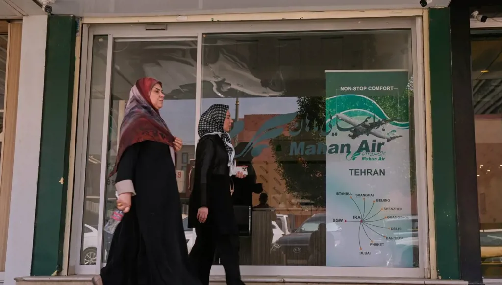 مشاة يسيرون أمام مكتب شركة الطيران الإيرانية «ماهان إير» في بغداد (أ.ب)