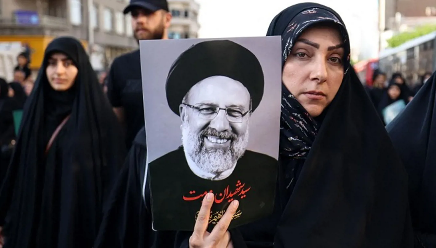 امرأة تحمل صورة الرئيس الإيراني الراحل إبراهيم رئيسي.