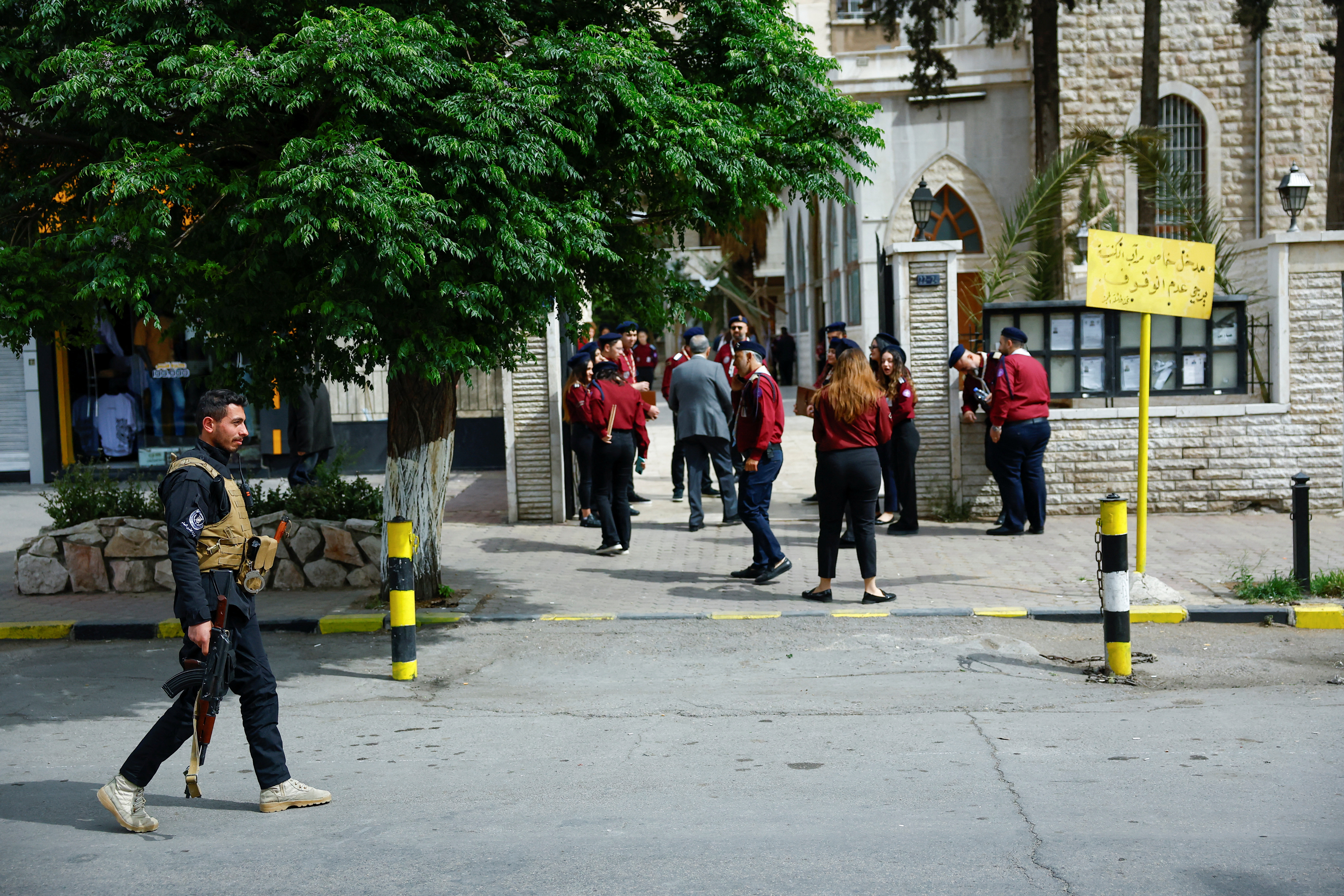رجل أمن سوري يمرّ قرب كنيسة في دمشق أثناء الاحتفال بأحد الشعانين. (رويترز)