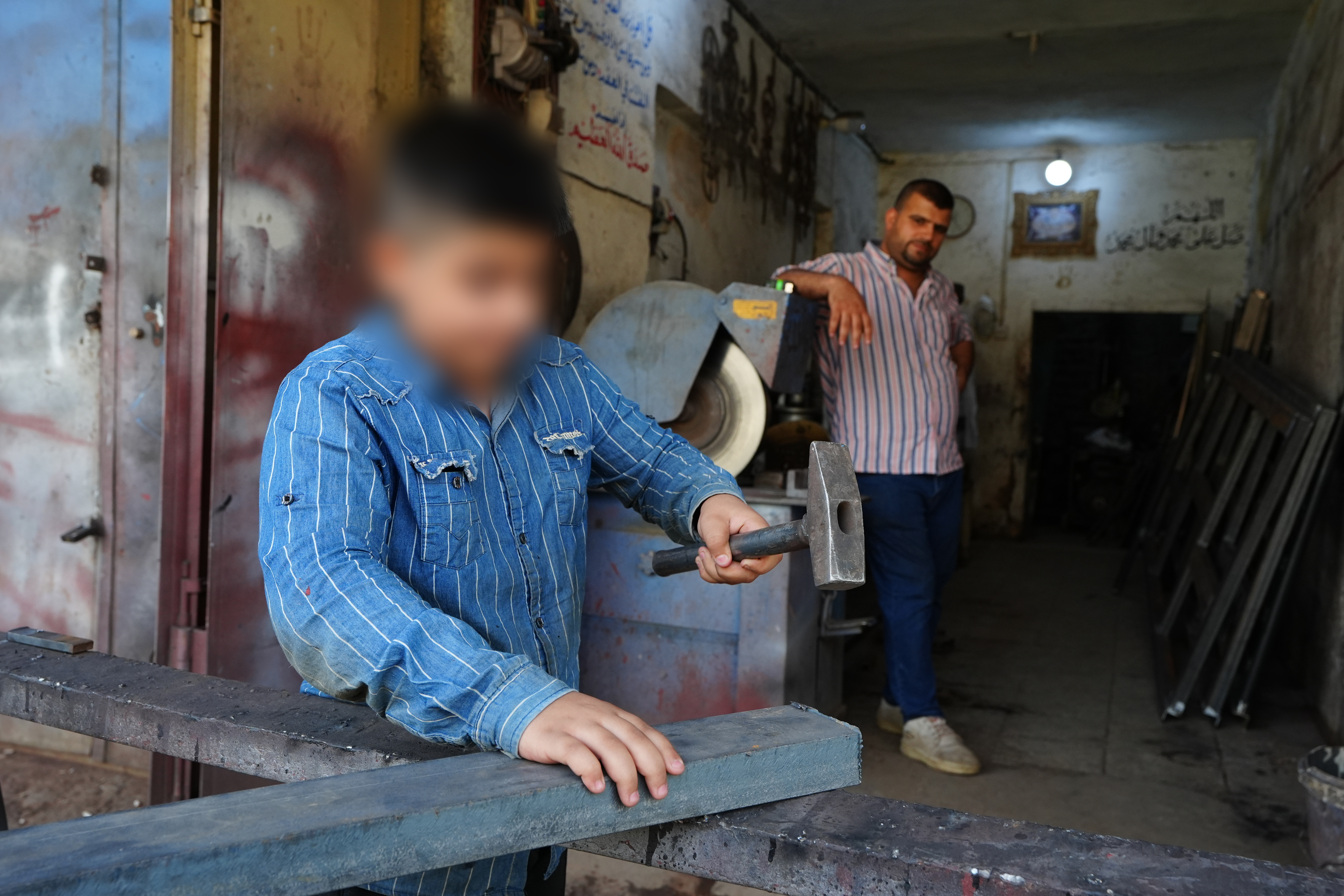 طفل يعمل في ورشة في بغداد رغم صغر سنه (11 حزيران 2025، رويترز). 