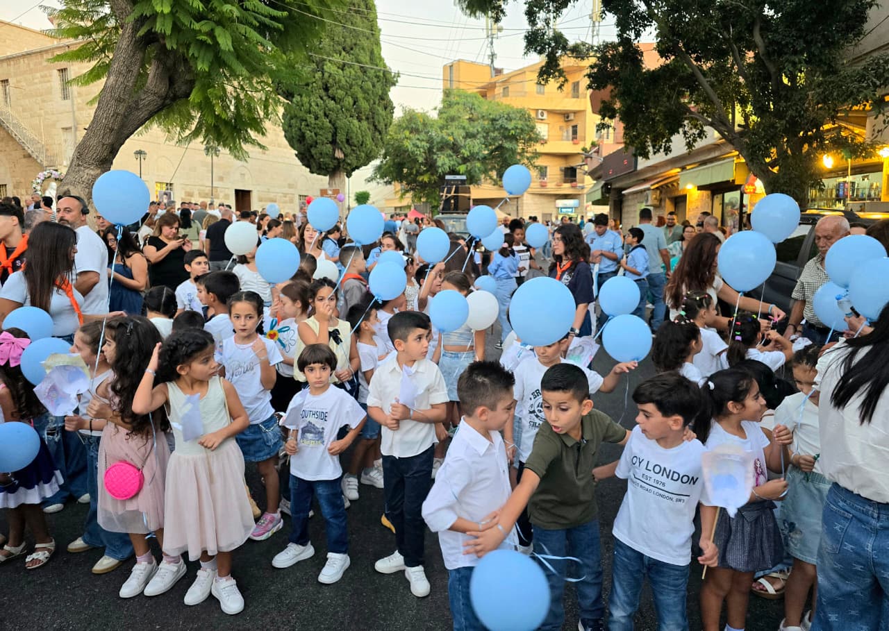 أطفال يرفعون بالونات في الزياح.
