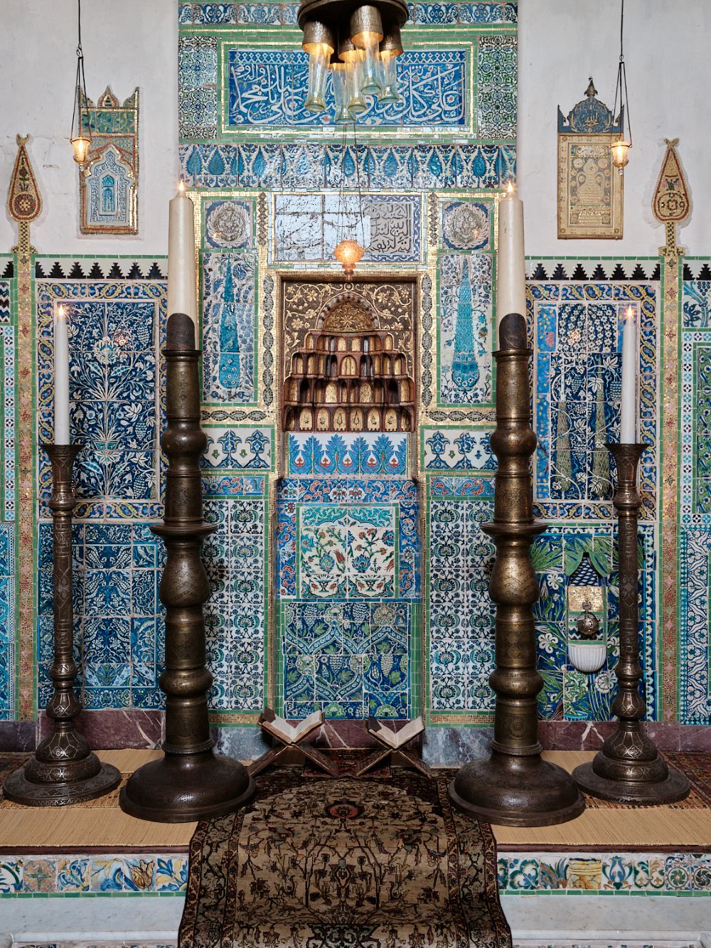 شمعدانات معدنية وبلاطات  خزفية تغطي الجدران