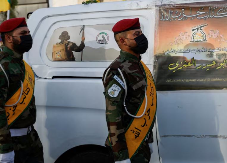 سيارة تحمل نعش أحد قادة كتائب حزب الله العراقية المسلحة في بغداد (رويترز)