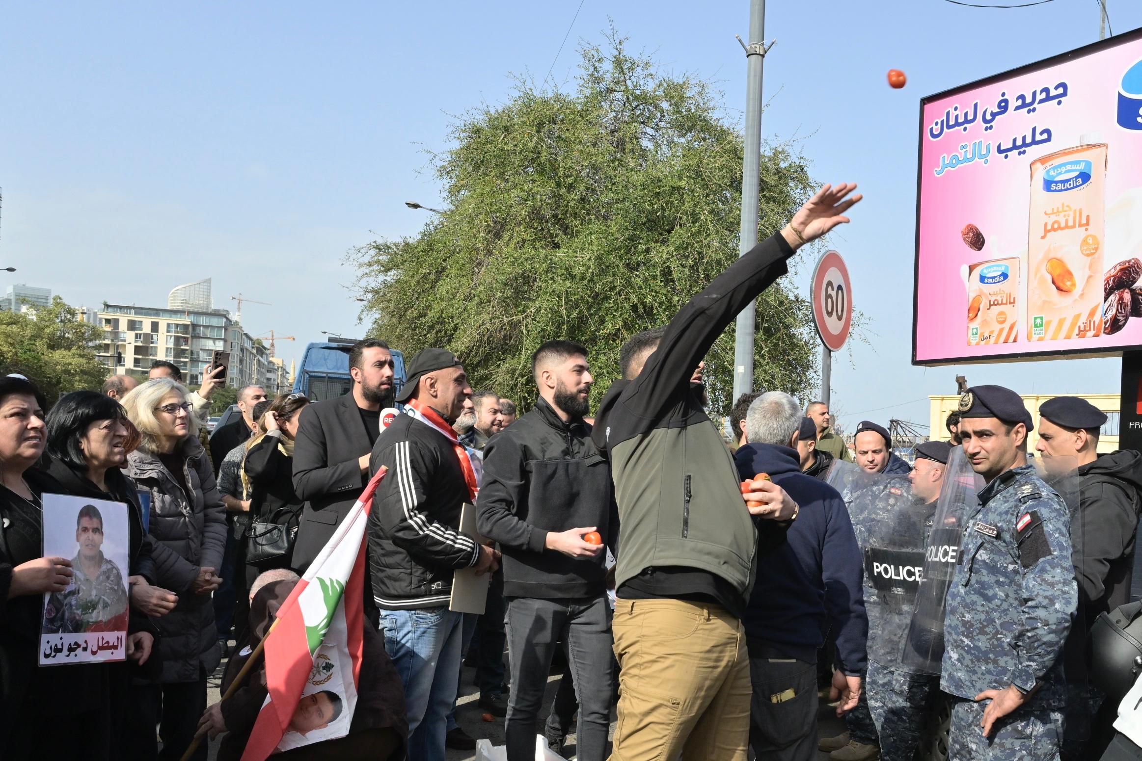 أهالي ضحايا انفجار مرفأ بيروت يرشقون مبنى الجمارك بالبندورة. (أ ف ب)