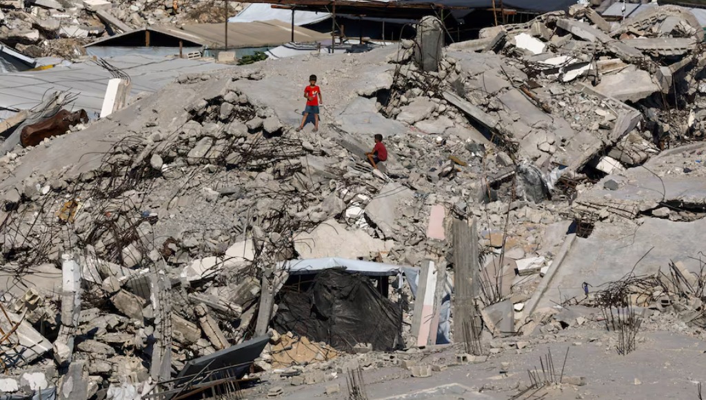 طفلان فلسطينيان وسط أنقاض المباني التي دمرت خلال الحرب في مخيم جباليا للاجئين شمال قطاع غزة (رويترز).