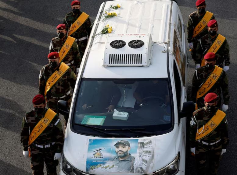 سيارة تحمل نعش أحد قادة كتائب حزب الله العراقية المسلحة في بغداد (رويترز)