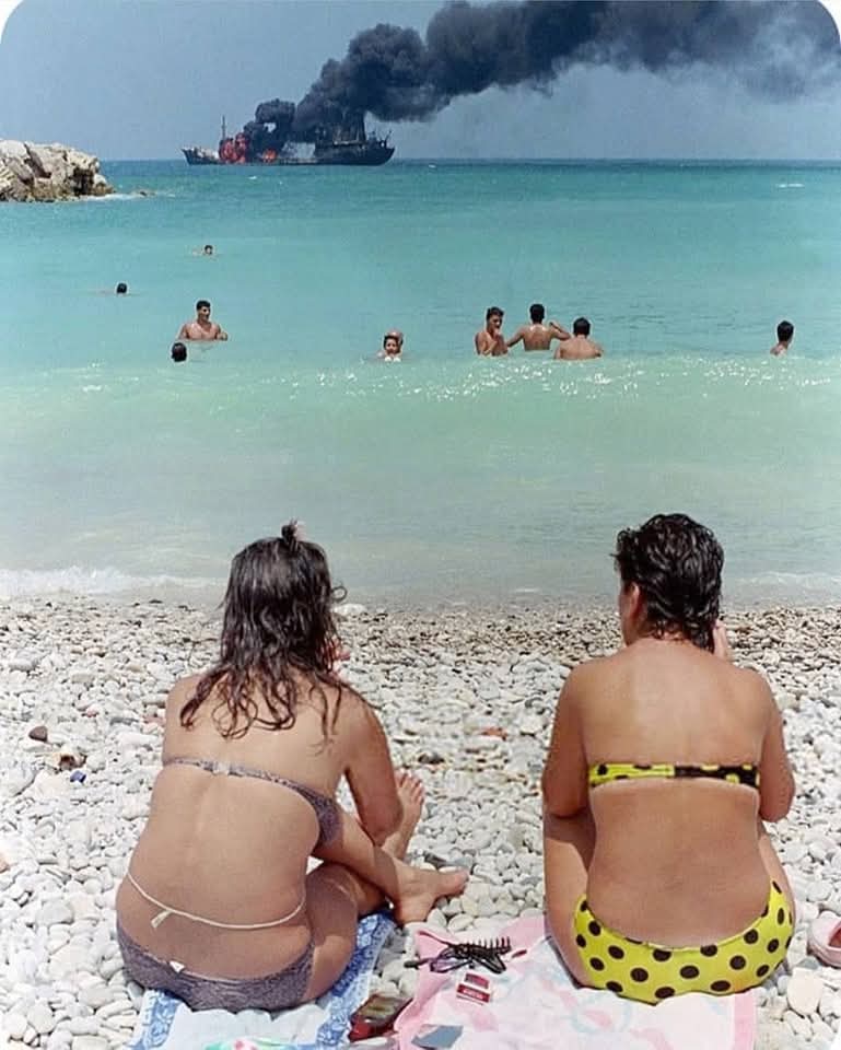 People swimming off a burning oil tanker due to Syrian army shelling of Jounieh port - June 1989 (Joseph Brack - AFP)