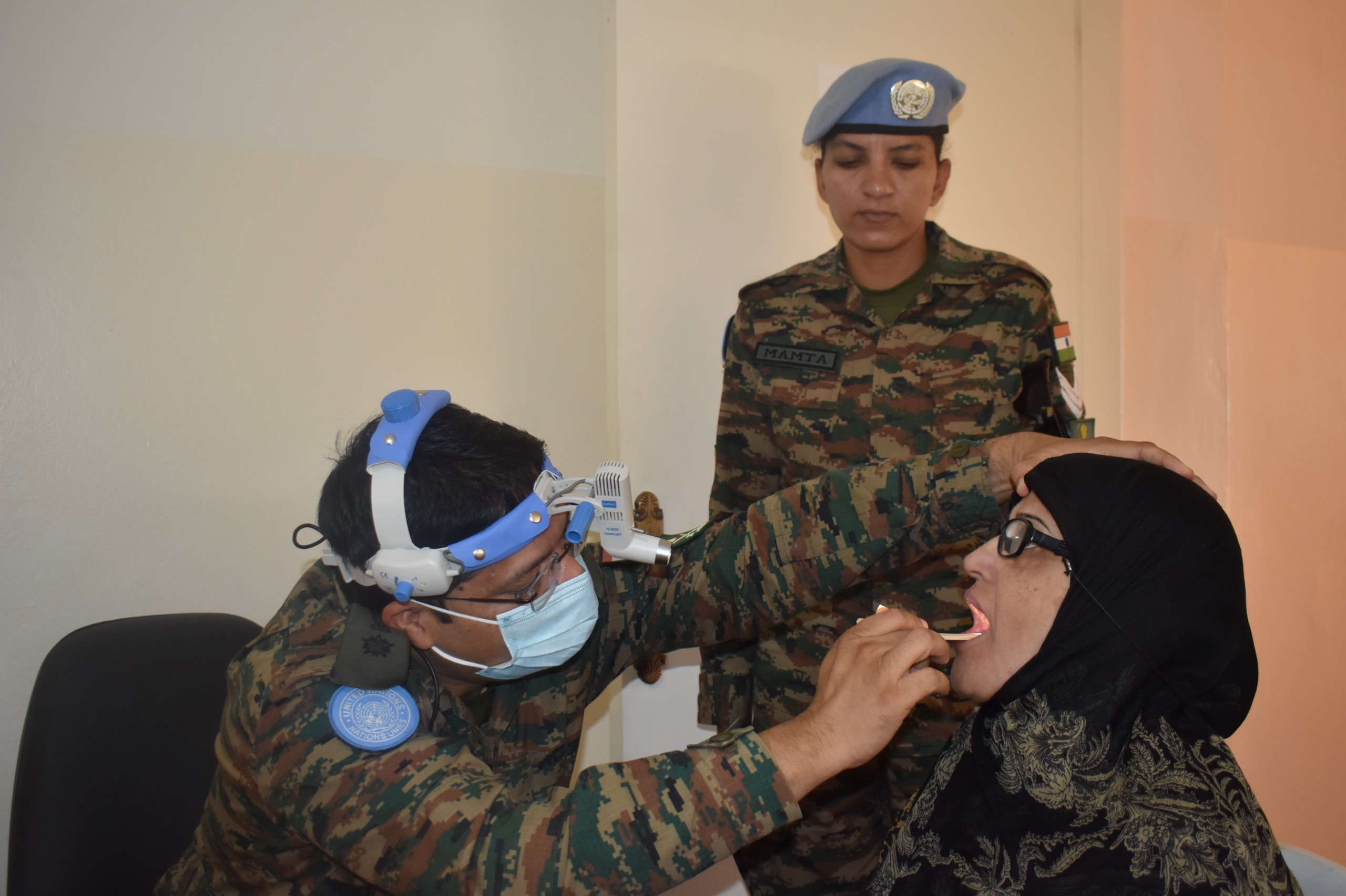  طبيب يعاين حنجرة مريضة بحضور مساعدته. (إ.أ.)