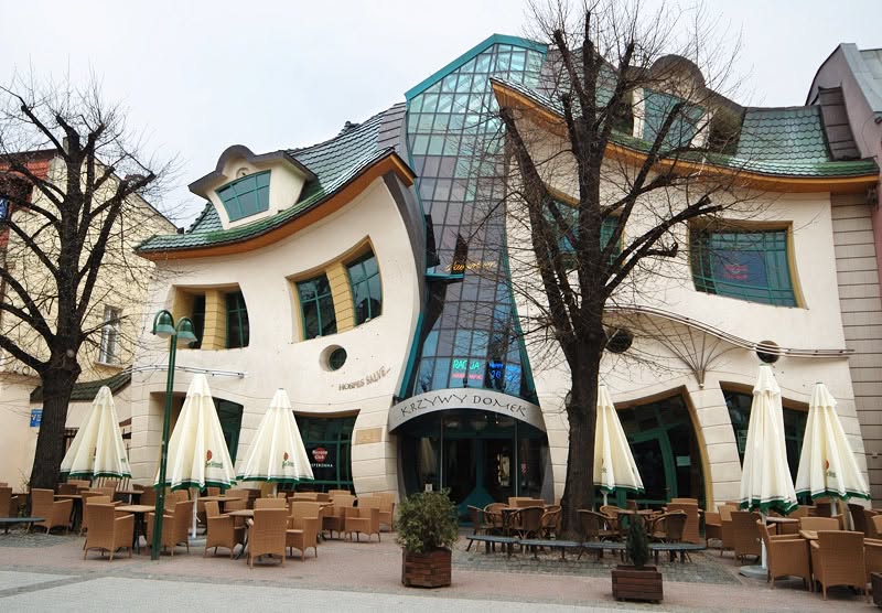 Crooked House في سوبوت البولندية، بواجهة متموجة ونوافذ مائلة تمنحه مظهراً كأنه يذوب أمام العين. (Visit Sopot)