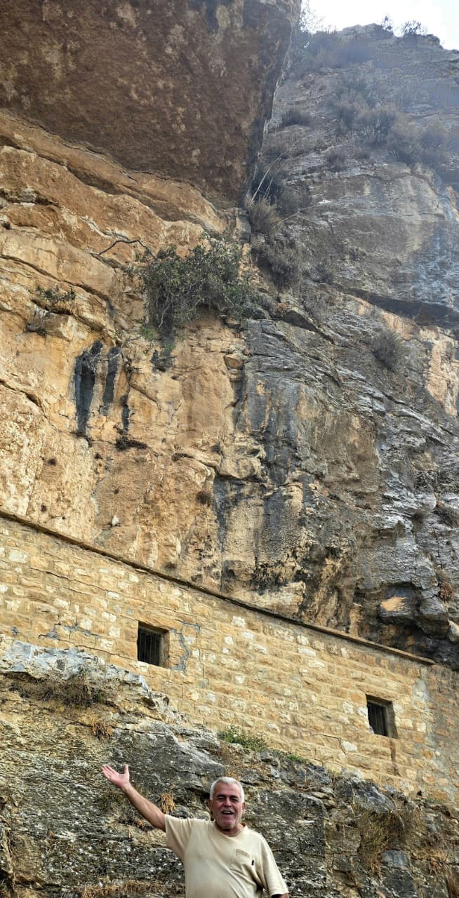 جدار صخري ضخم على جانب الطريق العام لمدخل القرية  من جهة طريق جزين_ باتر