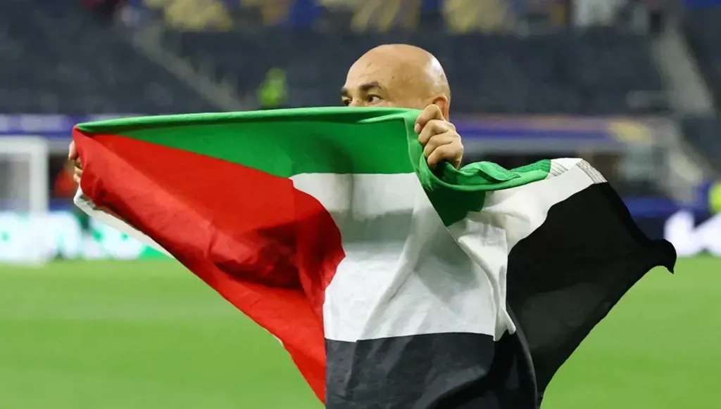 مدرب منتخب مصر حسام حسن رافعاً العلم الفلسطيني. (وكالات)