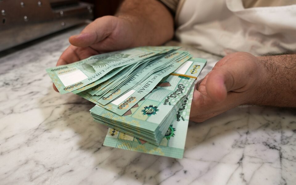 شخص يحمل أوراقا نقدية في يديه (رويترز)