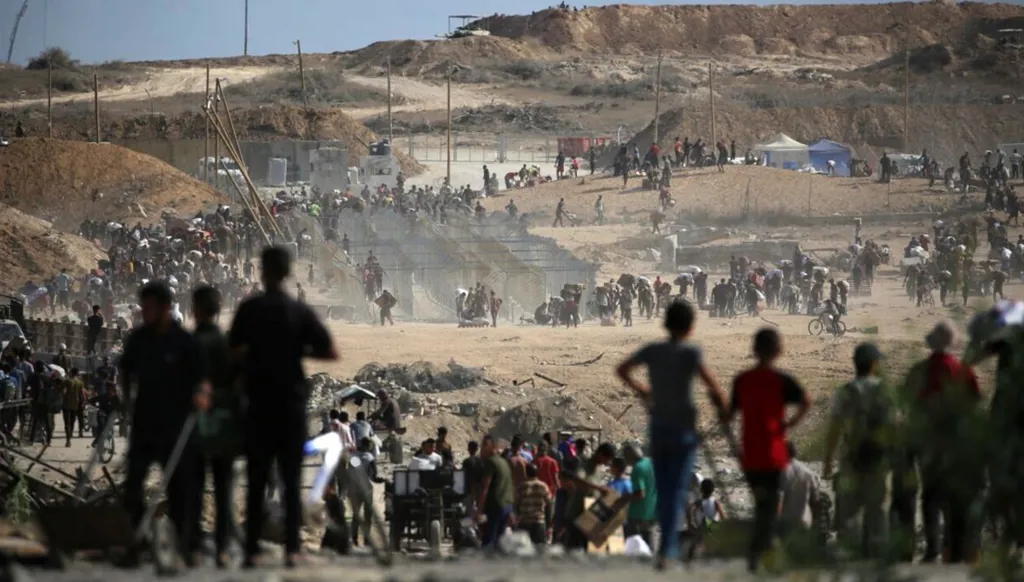 فلسطينيون يحملون أكياساً يعودون من نقطة توزيع الطعام التابعة لجمعية غزة الإنسانية، في 5 تشرين الأول/أكتوبر 2025. (أ ف ب)