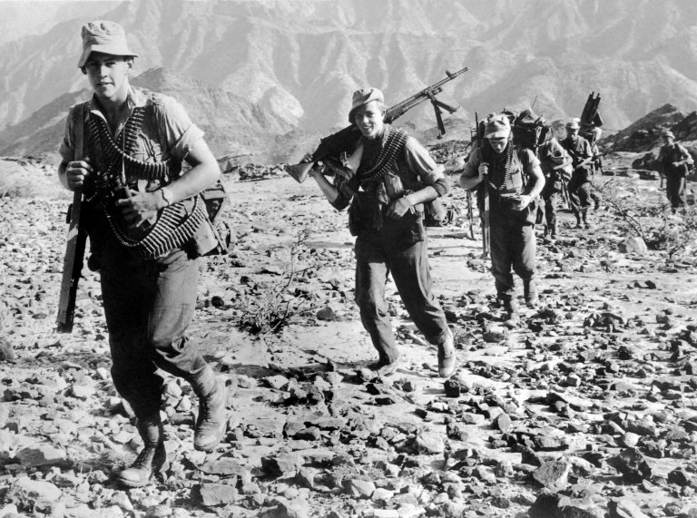 صورة نُشرت في 14 مايو/أيار 1964 لجنود مظليين بريطانيين يقاتلون مواقع القبائل المتمردة في تلال ردفان، التي كانت جزءًا من محمية الضالة البريطانية في عدن.. (أف ب)