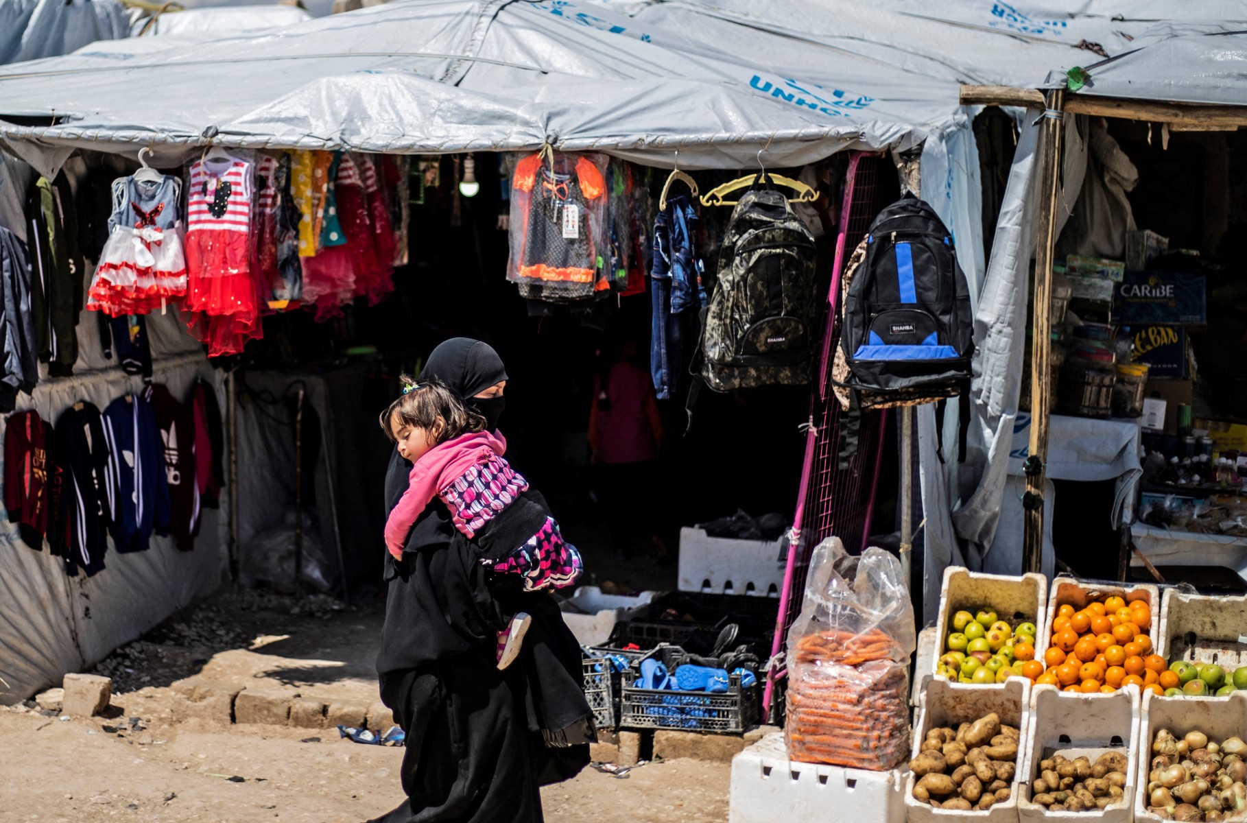 سيّدة نازحة من ريف دير الزور تحمل طفلاً في مخيم الهول بالحسكة، 18 نيسان 2019. (أ ف ب)