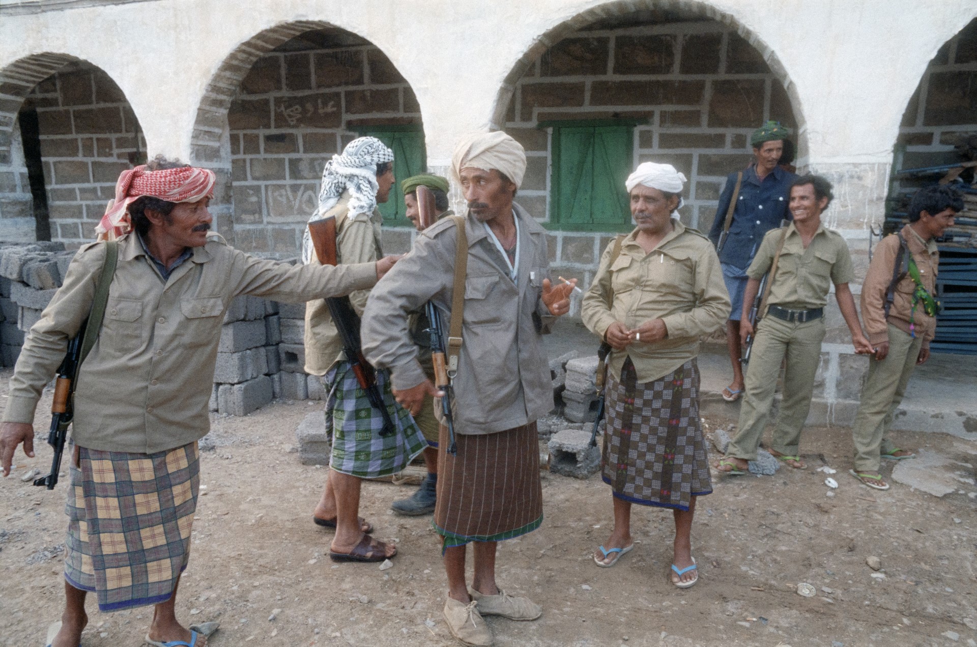 مقاتلون يدعمون القيادي البارز في الحزب الاشتراكي اليمني عبد الفتاح إسماعيل أمام موقع مهجور تركه أنصار الرئيس علي ناصر محمد في 4 فبراير 1986 في لودر قرب الحدود مع شمال اليمن.(أف ب)