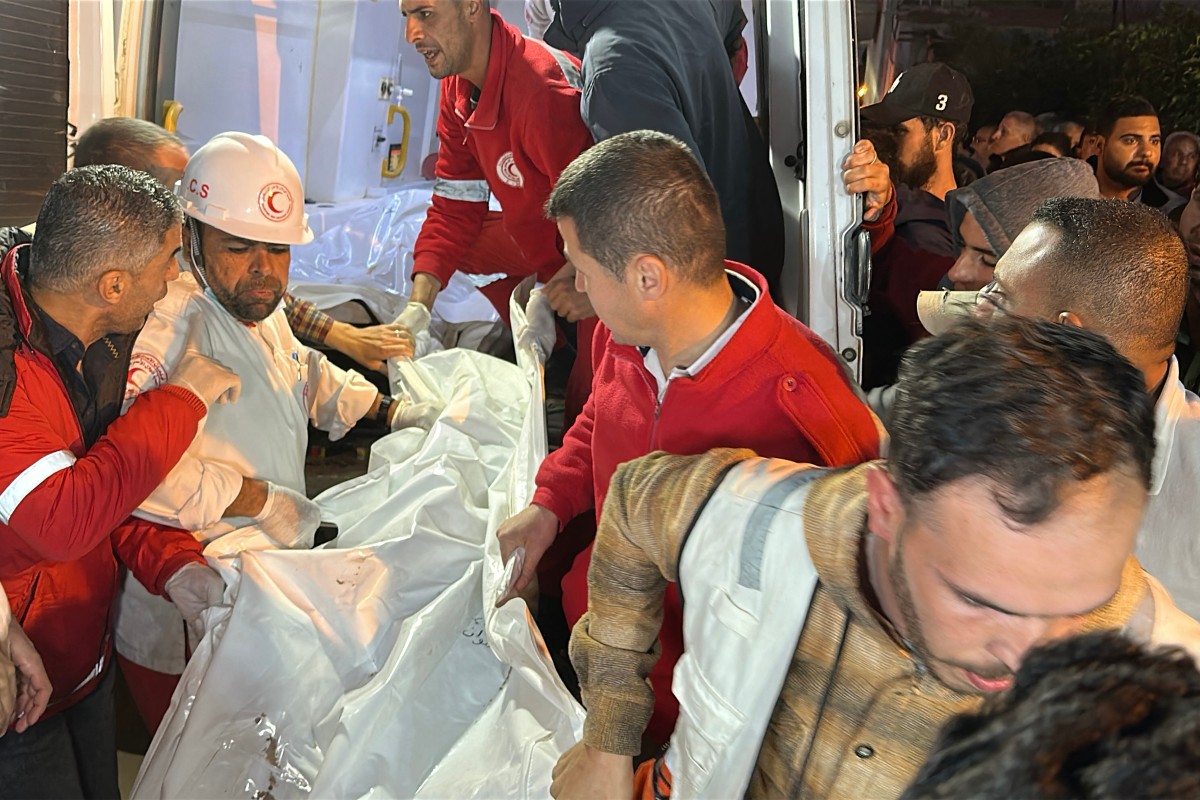 مسعفون ينقلون من سيارة إسعاف بعض جثث المسعفين الفلسطينيين الذين قُتلوا في غزة (ا ف ب)