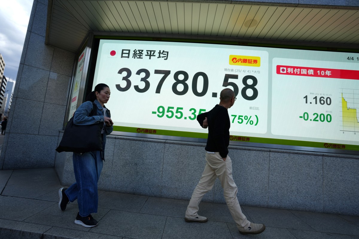 مارة يمرون بجانب لوحة إلكترونية تظهر أرقام إغلاق مؤشر نيكي في بورصة طوكيو، (ا ف ب).