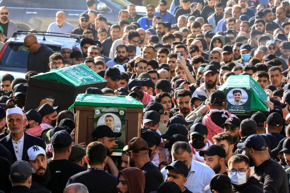 مشيعون يحملون نعش القيادي في حركة حماس حسن فرحات (وسط) ونجله حمزة (يمين) وابنته جنان (يسار)، الذين قتلوا في غارة إسرائيلية في مدينة صيدا جنوب لبنان (أ ف ب)