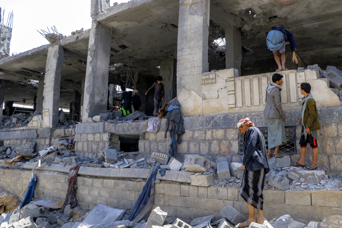 أشخاص يتفقدون مبنى متضرر بشدة يستخدم لتخزين ألواح الطاقة الشمسية والذي ورد أنه تعرض لضربة جوية أميركية في محافظة صعدة شمال اليمن في 6 أبريل 2025 