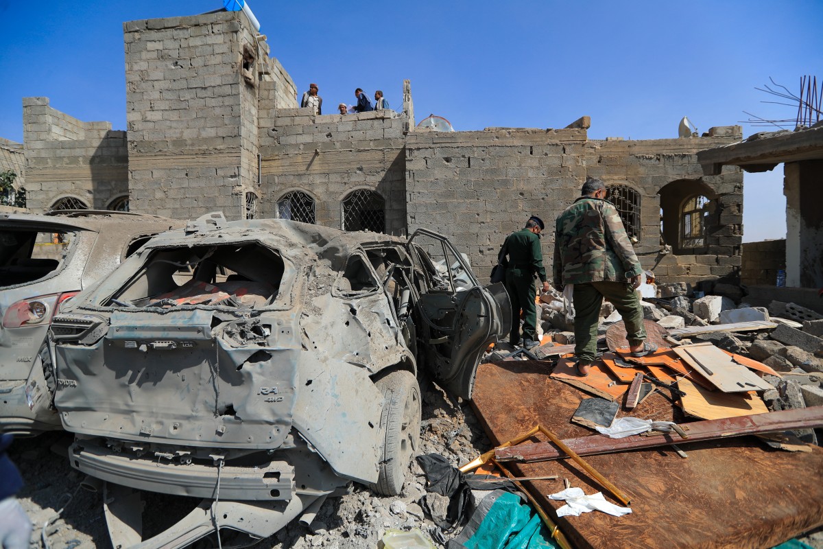 الحوثيون يتفقدون موقع غارة جوية أميركية في صنعاء (أ  ف ب). 