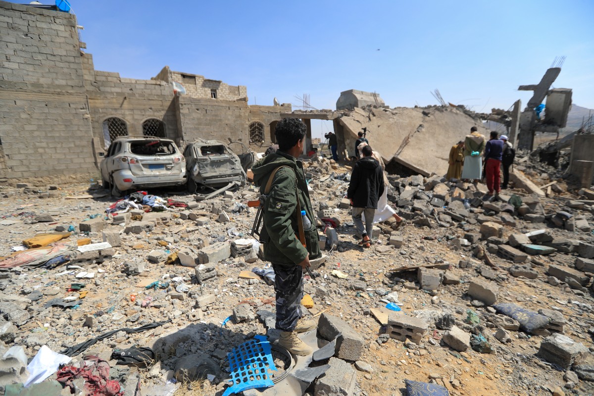 مقاتلون حوثيون يتفقدون موقع غارة جوية أميركية في صنعاء (ا ف ب)