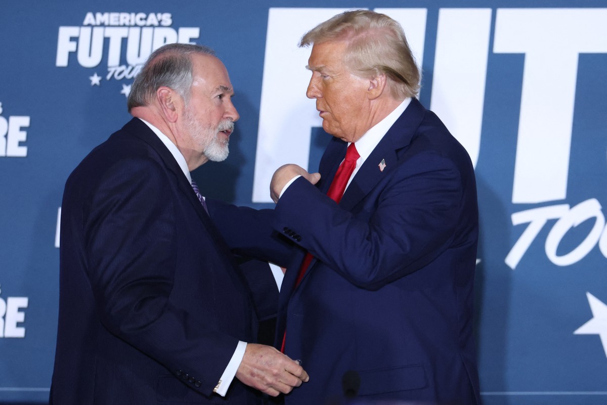 يتصافح الرئيس الأميركي دونالد ترامب ومايك هاكابي بعد المشاركة في مناقشة مائدة مستديرة استضافتها مؤسسة بناء مستقبل أميركا في دريكسل هيل بولاية بنسلفانيا، في 29 أكتوبر 2024 