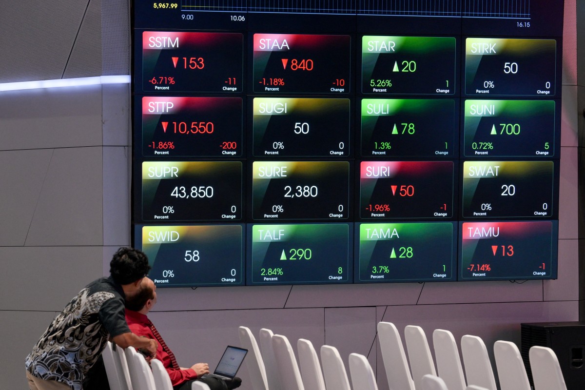 أشخاص يراقبون حركة أسعار الأسهم المركبة في بورصة إندونيسيا (أ ف ب)