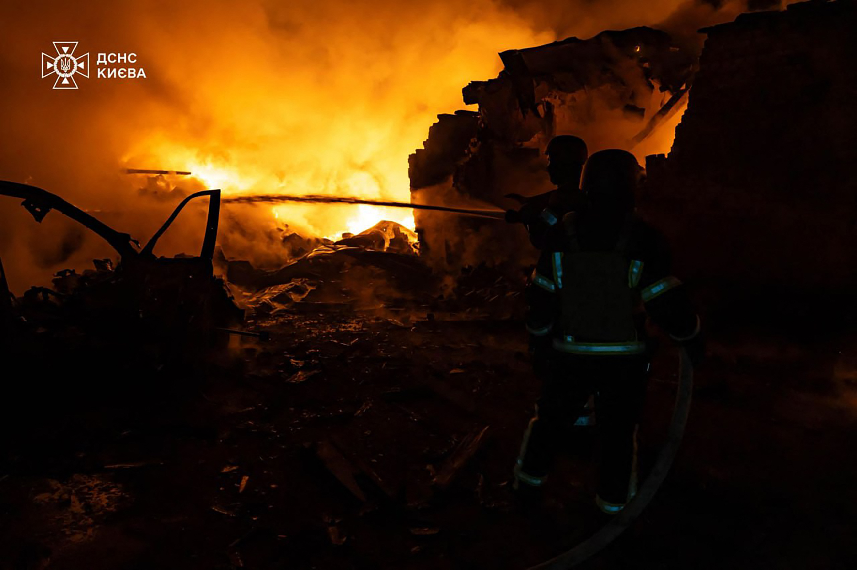  رجال الإنقاذ الأوكرانيون يعملون على إطفاء حريق في موقع هجوم بطائرة بدون طيار في كييف. (أ ف ب)