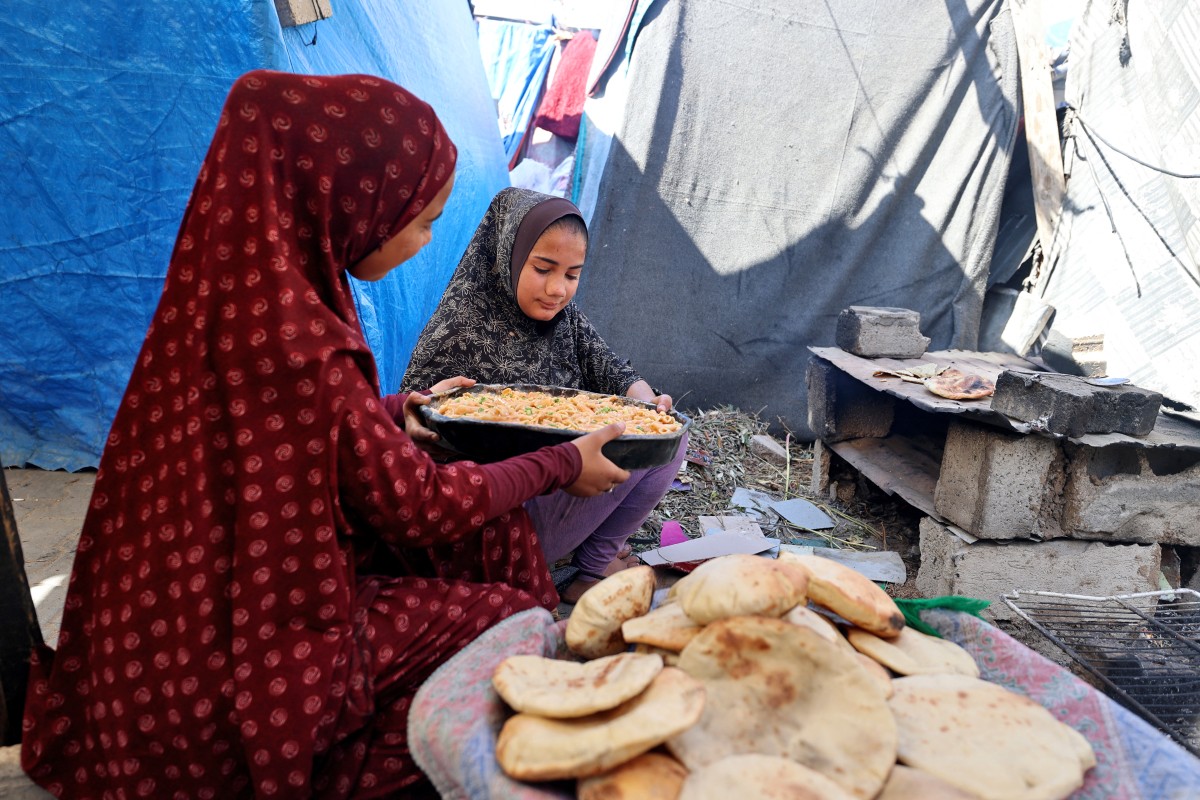 نازحون فلسطينيون يخبزون الخبز في مخيم البريج للاجئين وسط قطاع غزة (أ ف ب)
