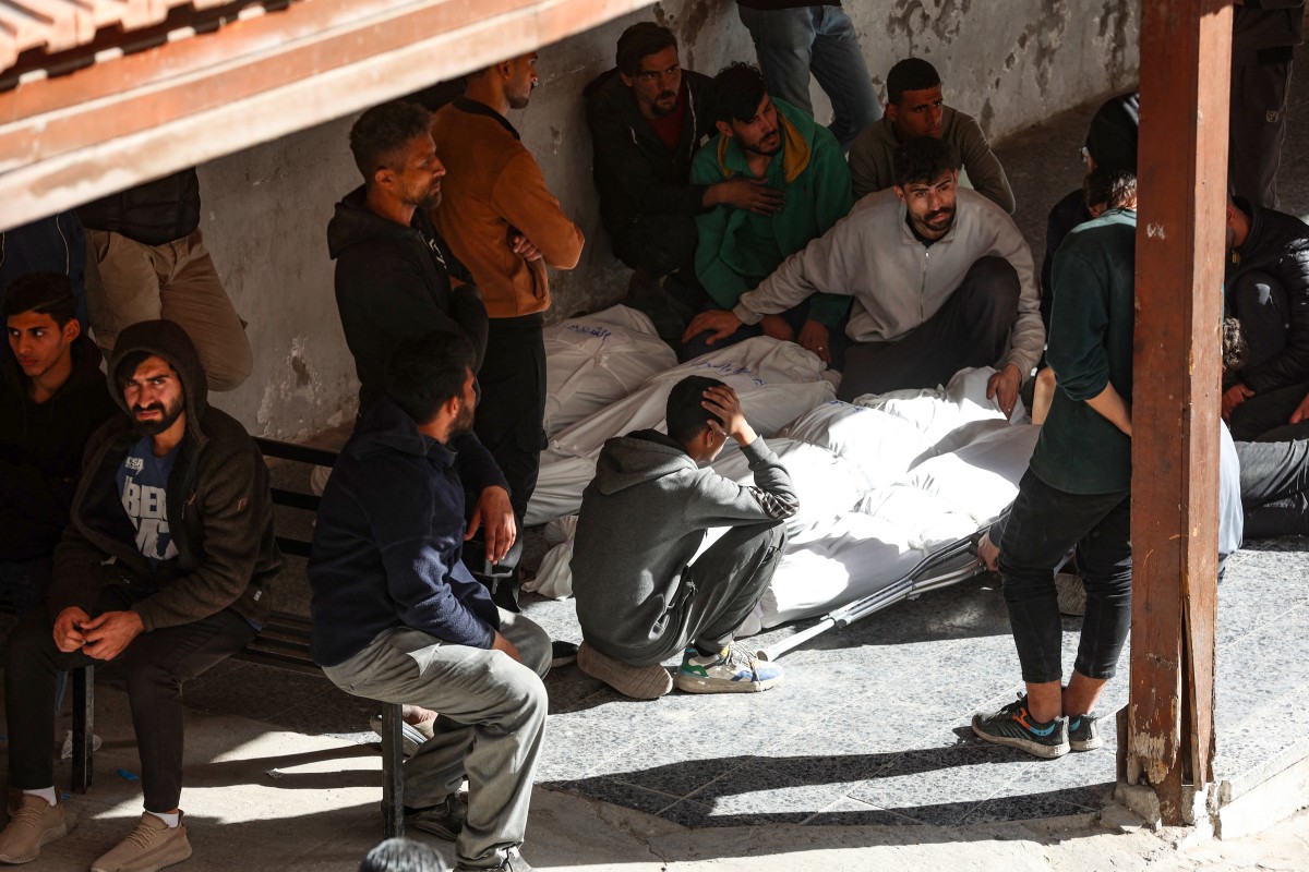 فلسطينيون يحيطون بجثث القتلى الذين قُتلوا في غارة إسرائيلية استهدفت مبنى في حي الشجاعية شرقي مدينة غزة (أ ف ب)