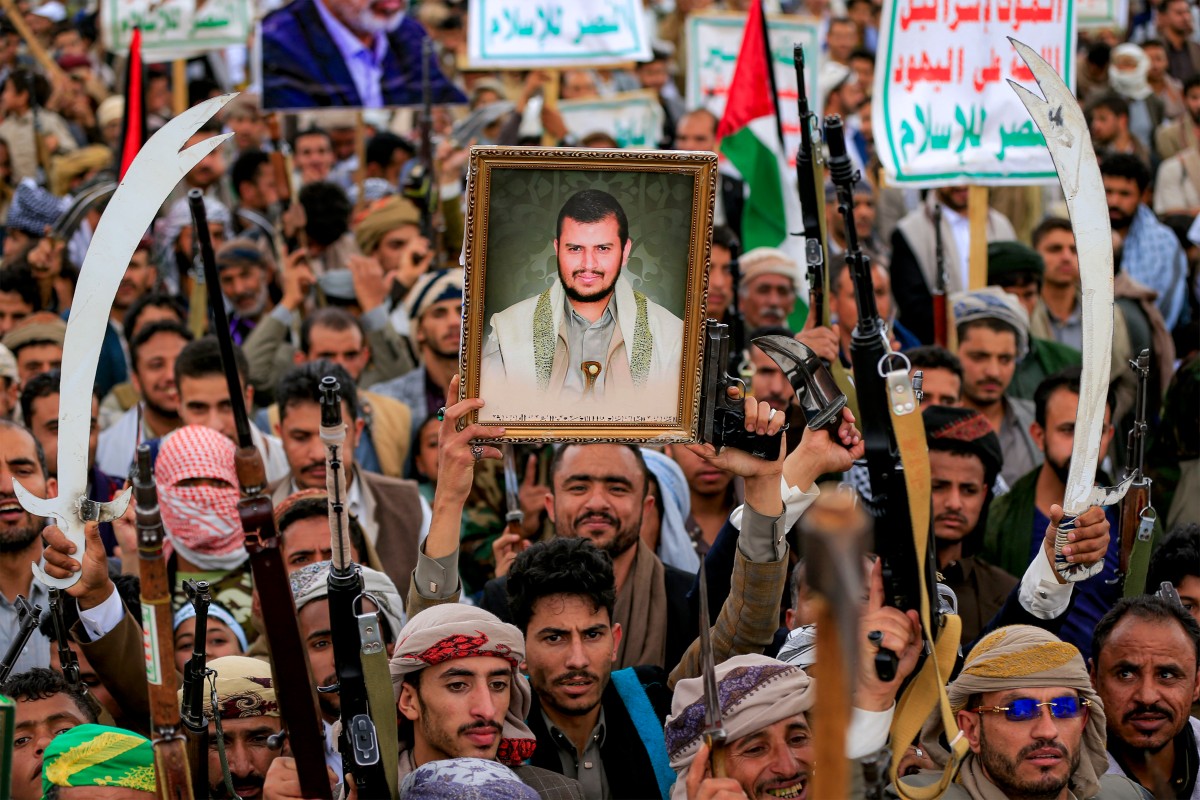 متظاهر يحمل صورة عبد الملك الحوثي خلال احتجاج في صنعاء. (ا ف ب) 