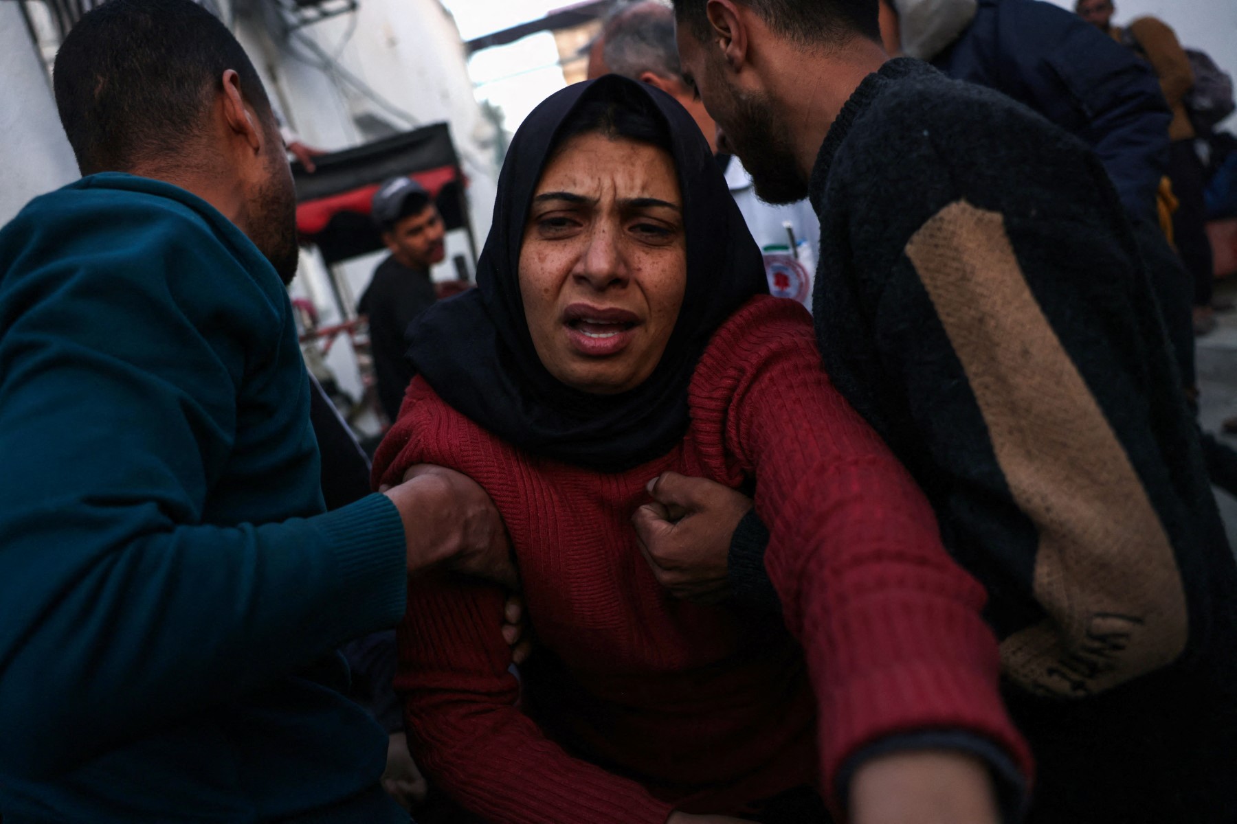 فلسطينيون يبكون أثناء نقل أحد ضحايا القصف الإسرائيلي على حي الشجاعية إلى المستشفى الأهلي العربي. (ا ف ب)