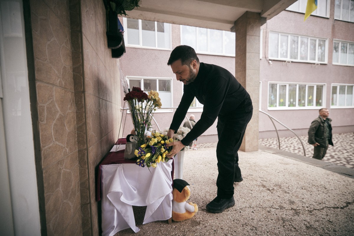 الرئيس الأوكراني فولوديمير زيلينسكي وهو يكرّم ذكرى القتلى الذين سقطوا في غارة صاروخية روسية. (أ ف ب)