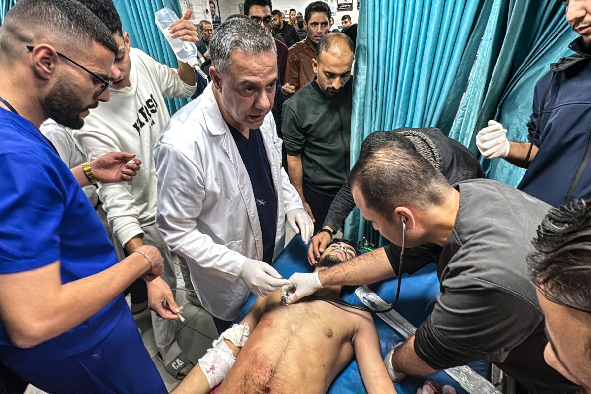 حسام أبو صفية (وسط) يشرف على علاج رجل فلسطيني أصيب في غارة إسرائيلية على بيت لاهيا شمال قطاع غزة (ا ف ب)