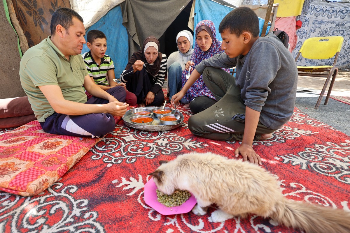 فلسطينيون يأكلون في مخيم النصيرات للاجئين وسط قطاع غزة (ا ف ب)