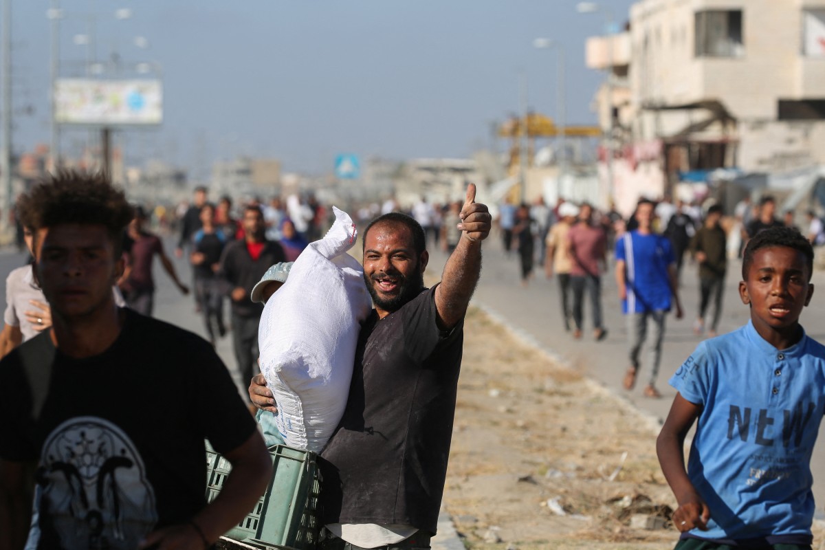 فلسطينيون يحملون اكياس مساعدات في غزة (ا ف ب)