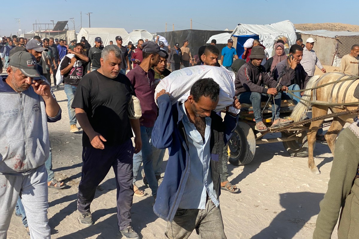 نازحون فلسطينيون يحملون أكياساً من مواد الإغاثة يعودون من مراكز توزيع المساعدات في رفح إلى خيامهم في جنوب قطاع غزة في 29 مايو 2025 (أ ف ب)