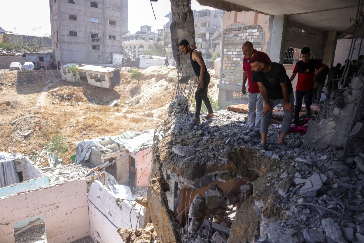 فلسطينيون يتفقدون الأضرار في حي سفتاوي غرب جباليا شمال قطاع غزة (أ ف ب)