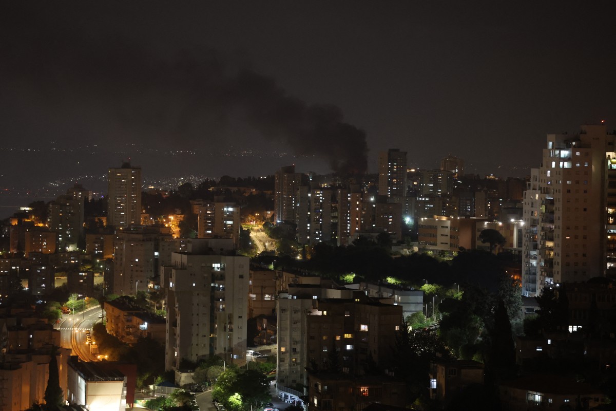 تصاعد الدخان من موقع في مدينة حيفا عقب وابل جديد من الهجمات الصاروخية الإيرانية (أ ف ب)