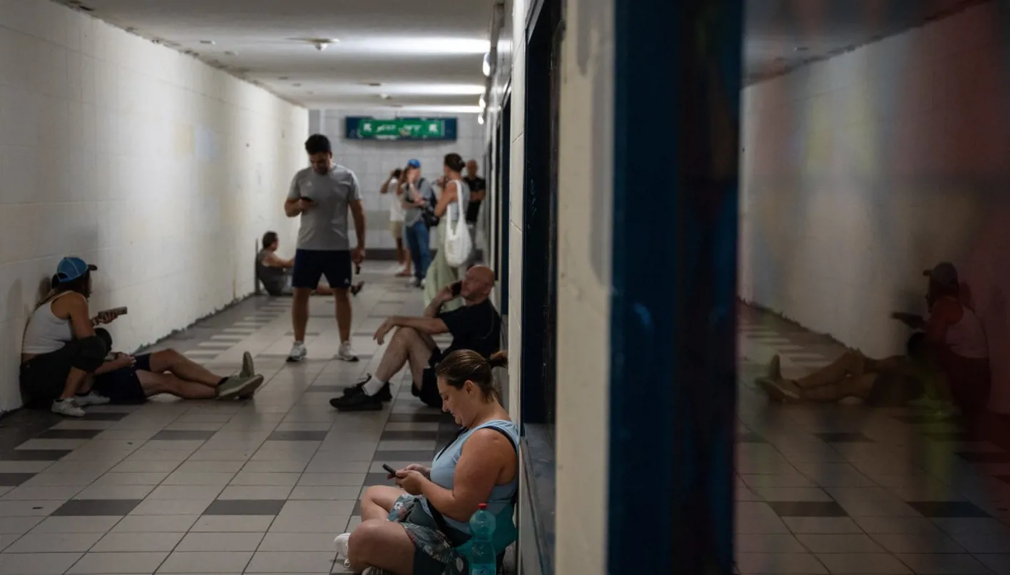 إسرائيليون يحتمون أثناء إطلاق صافرات الإنذار بالصواريخ في حيفا (أ ف ب).