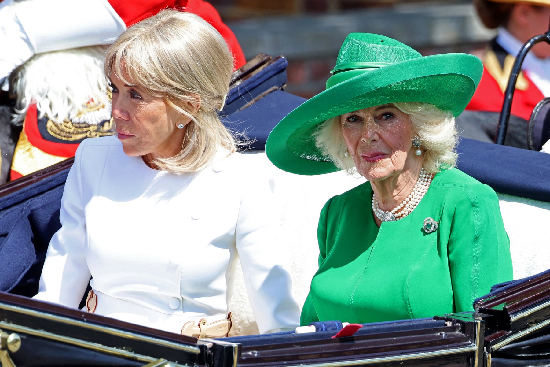 الملكة كاميلا تتألّق بالأخضر الزمردي إلى جانب السيدة الأولى بريجيت ماكرون (أ.ف.ب)