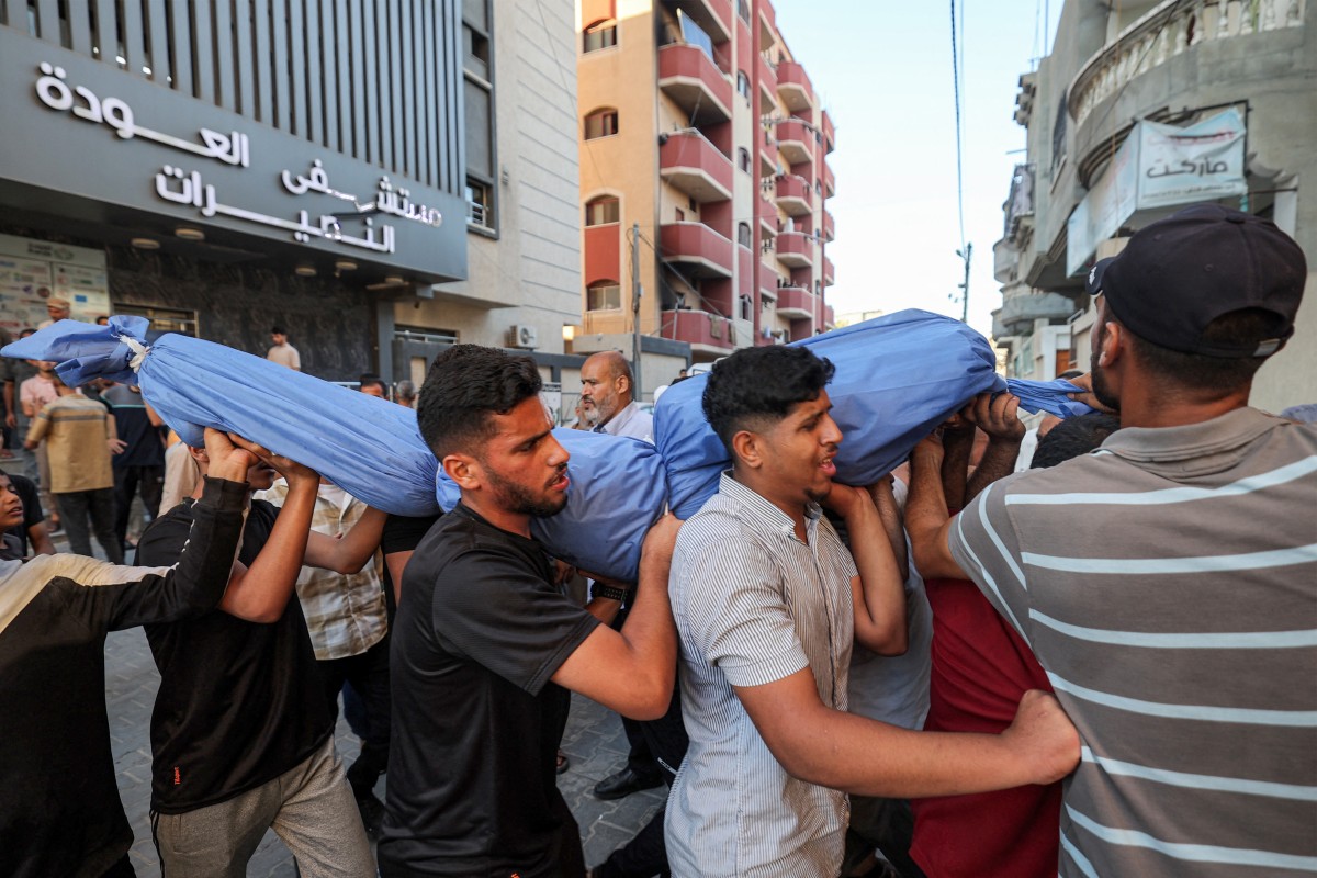 فلسطينيون في غزة يحملون جثمان أحد الضحايا (أ ف ب)