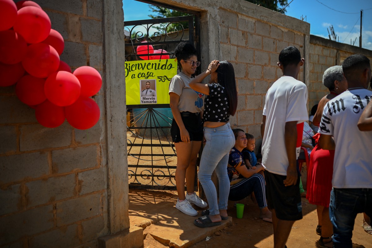 فنزويلية تنتظر وصول شقيقها  الذي أعيد من سجن في السلفادور. (أ ف ب)