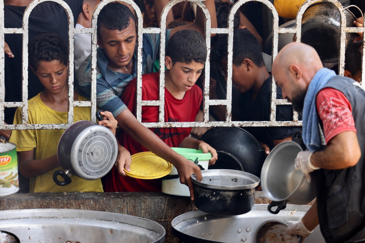فلسطينيون ينتظرون الحصول على طعام (أ ف ب).
